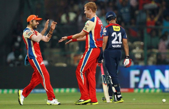 Andrew McDonald and Virat Kohli celebrate the wicket of Virender Sehwag on Tuesday