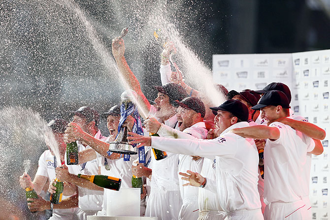 England's captain Alastair Cook lifts the replica Ashes urn and celebrates with teammates after the fifth Ashes Test ended in a draw and England won the series 3-0 at the Oval cricket ground in London on Sunday