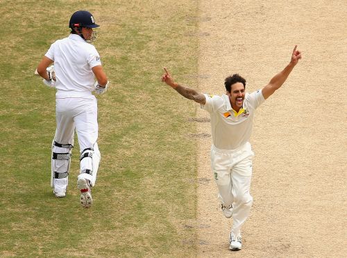 Mitchell Johnson of Australia celebrates after taking the wicket of Alastair Cook