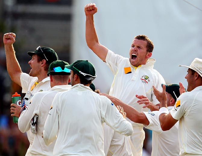 Peter Siddle (centre) celebrates with his team mates after getting the wicket of Ian Bell