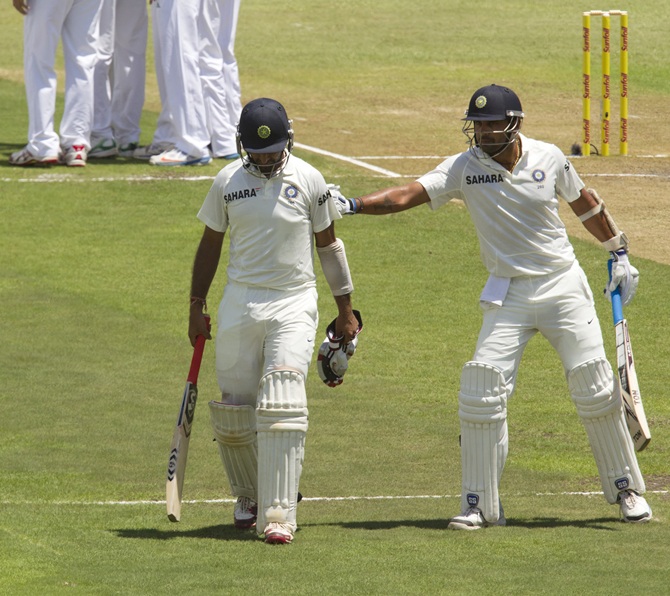 India's Cheteshwar Pujara is consoled by team mate Murali Vijay after getting out