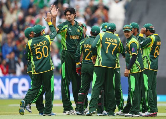 Muhammad Irfan (3L) of Pakistan receives team mates congratulations after taking the wicket of Faf Du Plessis of South Africa