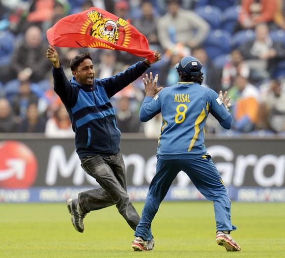 A Sri Lankan protester runs towards Kushal Perera 