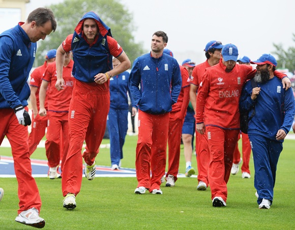 Stuart Broad of England jogs back to the dressing room with team mates after rain begins to fall prior to the ICC Champions Trophy final