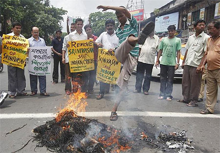 A protester kicks a burning effigy of Indian cricket board (BCCI) President N Srinivasan during a protest demanding Srinivasan's resignation in Kolkata on Sunday