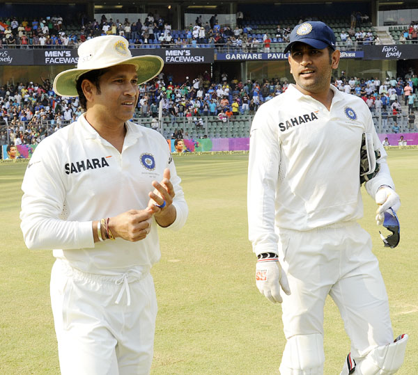 Sachin Tendulkar of India and Mahendra Singh Dhoni captain of India walk to field during day three