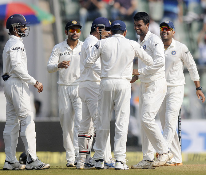 Pragyan Ojha of India celebrates the wicket of Chris Gayle of West Indies