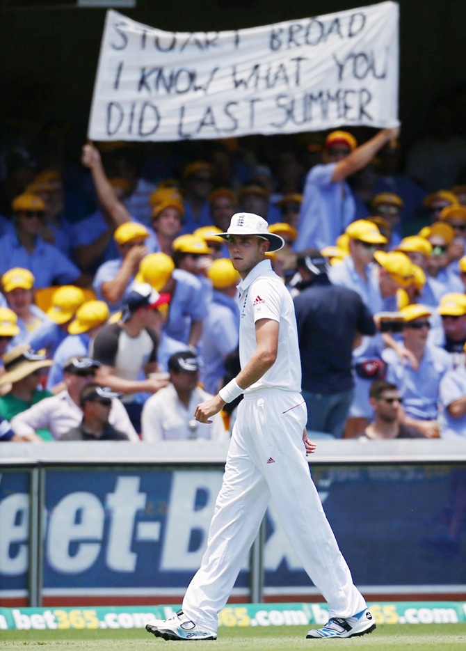 England's Stuart Broad stands in the outfield in front of a spectator's sign about him