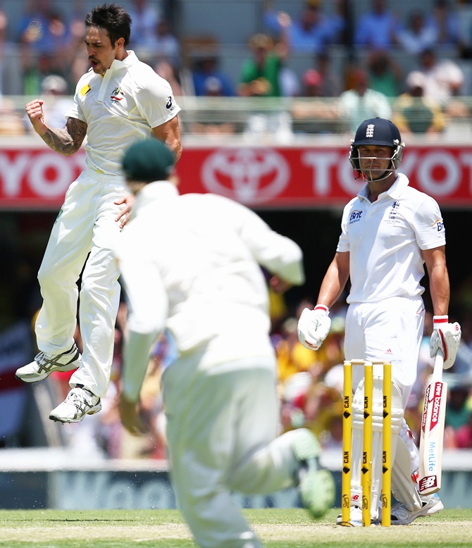 Mitchell Johnson of Australia celebrates after taking the wicket of Jonathan Trott of England