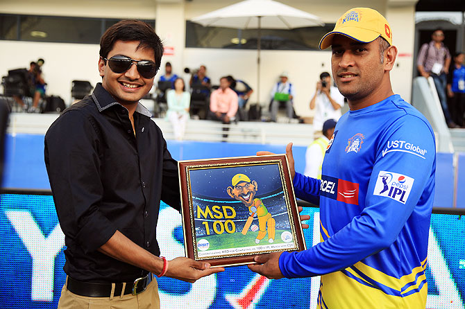 Chennai Super Kings' captain MS Dhoni receives a memento marking his 100th IPL match