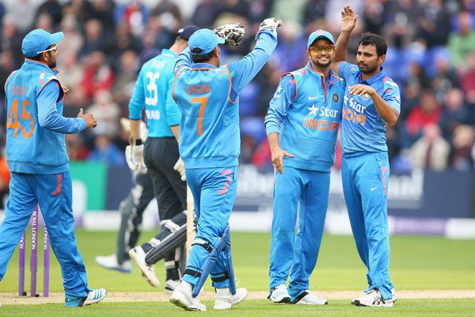 Mohammed Shami,right, of India celebrates with Suresh Raina, second right, and MS Dhoni after capturing the wicket of Alastair Cook of England