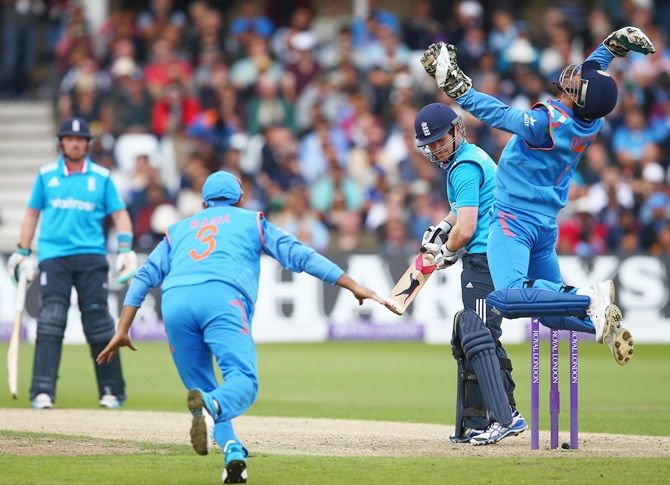 Mahendra Singh Dhoni of India celebrates taking a catch to dismiss Eoin Morgan of   England off the bowling of Ravichandran Ashwin