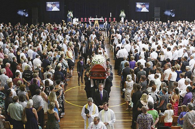 The casket containing Australian cricketer Phillip Hughes is carried past mourners at the end of his funeral service