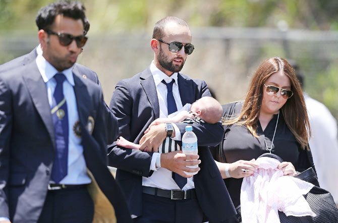 Australian cricketer Nathan Lyon arrives with his baby during the Funeral Service for Phillip Hughes