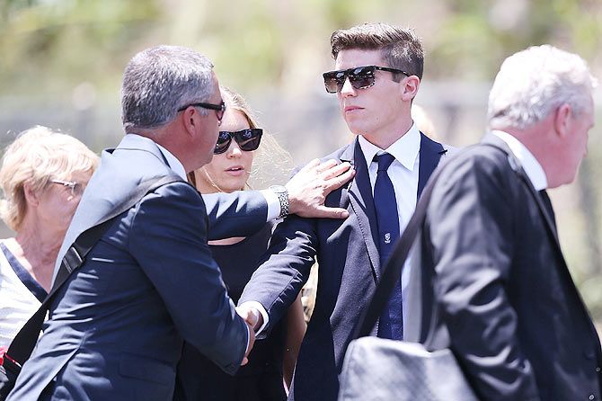 New South Wales cricketer Sean Abbott is consoled on arrival for Phillip Hughes's funeral service 
