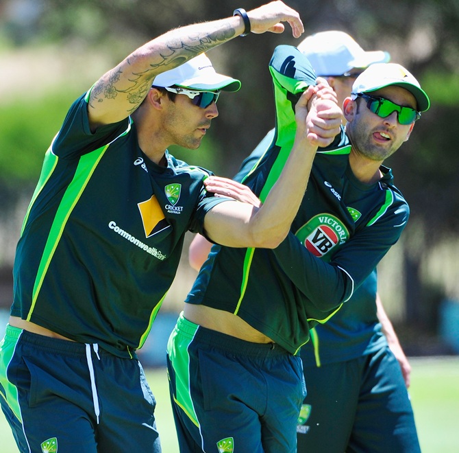 Mitchell Johnson and Nathan Lyon stretch during a practice session