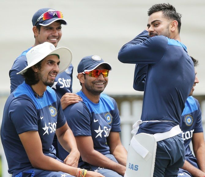Virat Kohli, right, speaks to his teammates during a training session