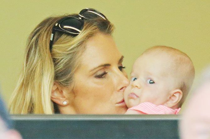 Candice Falzon, fiancee of David Warner kisses their daughter Ivy after the Australian batsman completed his century on Tuesday