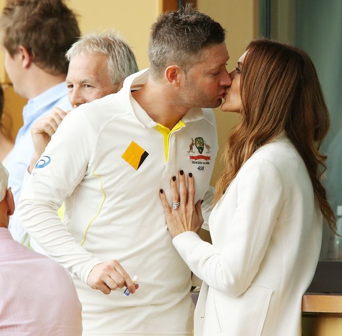 Michael Clarke of Australia kisses his wife Kyly Clarke during a rain delay during day two