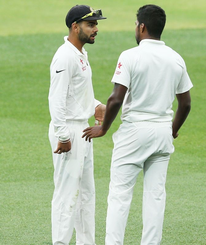 Virat Kohli of India speaks to his bowler Varun Aaron