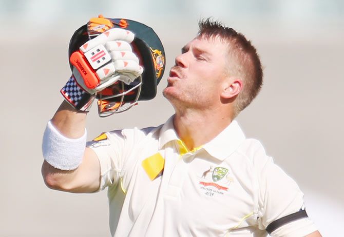 David Warner kisses the badge on his helmet after completing his century on Friday