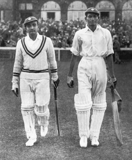 Vijay Merchant, left, and Syed Mushtaq Ali walk out to bat on Day 1 of the Test against England at Old Trafford, on July 25, 1936