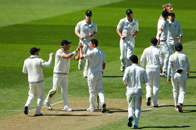 Neil Wagner of New Zealand congratulates teammate Trent Boult after taking the wicket of Ishant Sharma of India