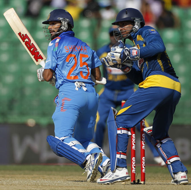 India's Shikhar Dhawan (left) plays a ball as Sri Lanka's wicketkeeper Kumar Sangakkara watches