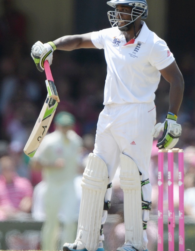 Michael Carberry of England holds up his broken bat