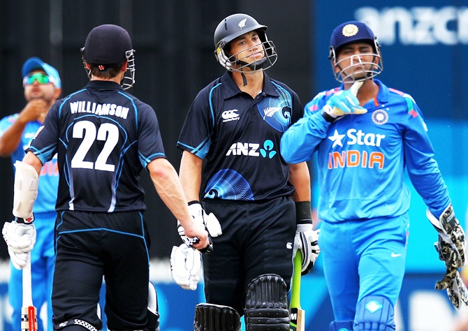 Ross Taylor of New Zealand reacts as MS Dhoni of India walks past
