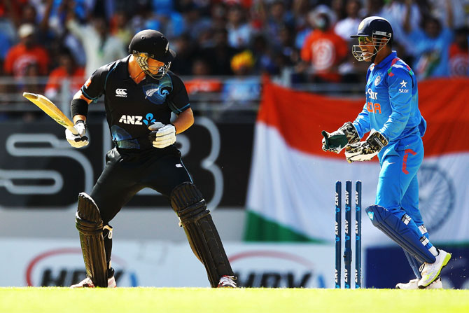 Corey Anderson of New Zealand looks at the stumps after being bowled by Ravichandran Ashwin of India as MS Dhoni celebrates