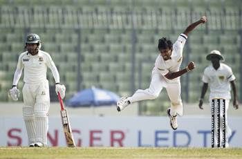 Sri Lanka's Suranga Lakmal bowls as Bangladesh's captain Mushfiqur Rahim (L) watches during the first day of the first Test in Dhaka