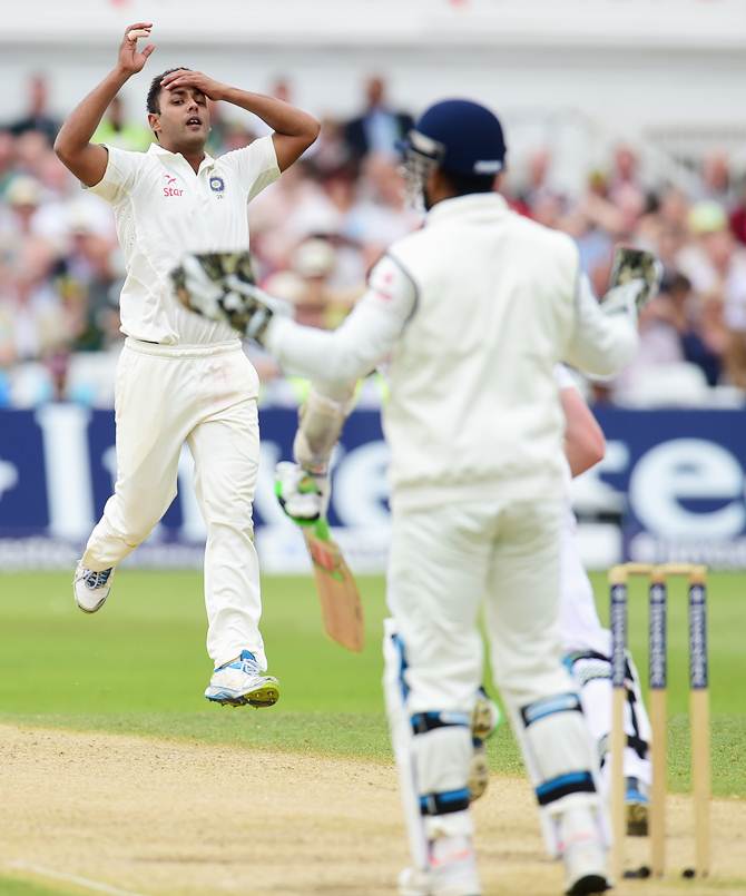 India bowler Stuart Binny and wicketkeeper Mahendra Singh Dhoni react after Sam Robson edges a delivery