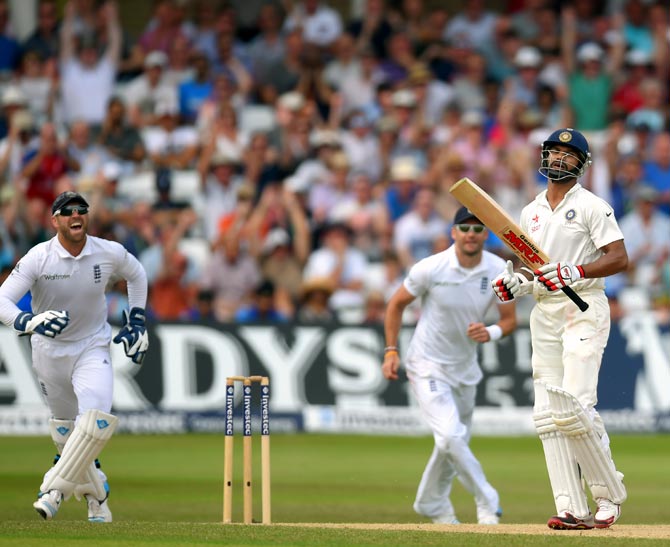 Shikhar Dhawan (right) is dejected after his dismissal as England's players celebrate