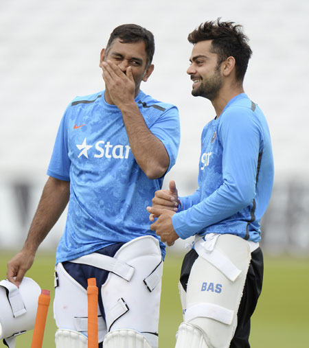 India's captain Mahendra Singh Dhoni (left) and Virat Kohli talk during a training session