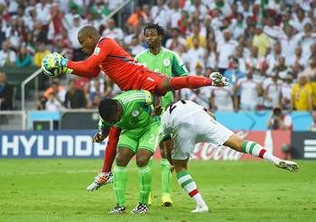 Vincent Enyeama of Nigeria makes a save over teammates Joseph Yobo and Ashkan Dejagah of Iran during the Group F World cup match at Arena da Baixada in Curitiba, Brazil. 
