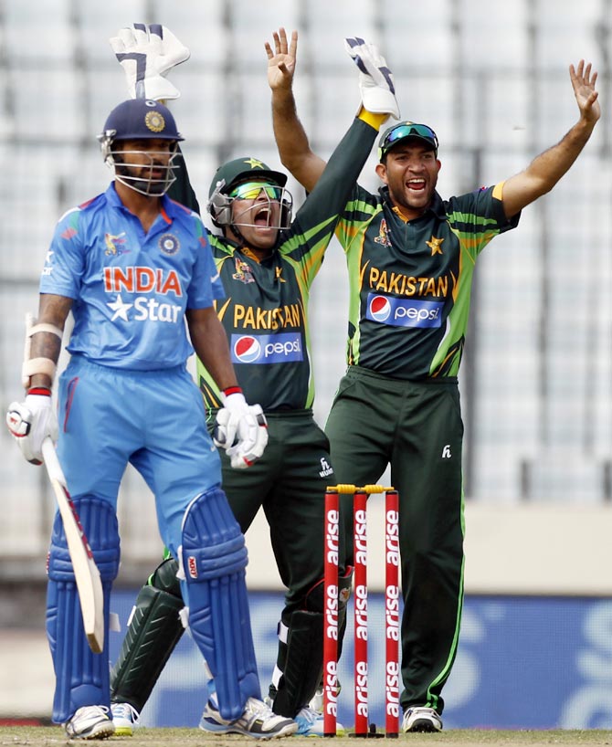 Shikhar Dhawan (left) looks on as wicketkeeper Umar Akmal and Shoaib Maqsood (right) appeal