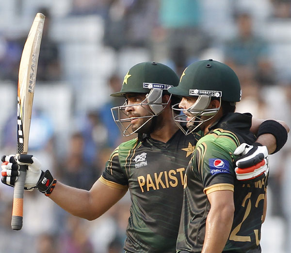 Pakistan's Umar Akmal celebrates after scoring a half century against Australia as teammate and brother Kamran Akmal (right) congratulates him