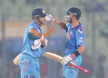 Virat Kohli and MS Dhoni of India embrace after clinching victory over Bangladesh on Friday