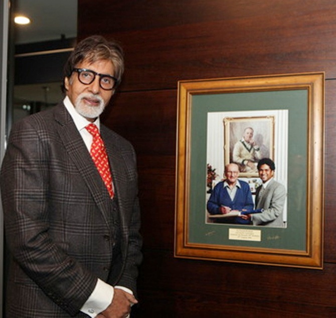 Amitabh Bachchan poses in front of a photograph of Sir Don Bradman and Sachin Tendulkar at the MCG museum, called the National Sports Museum