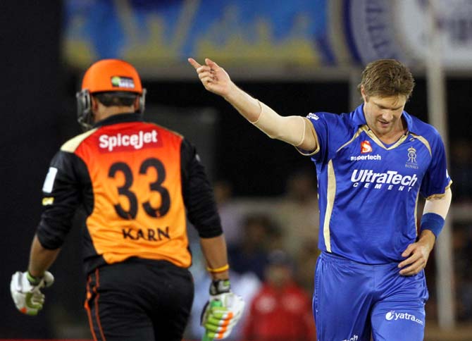 Shane Watson (right) celebrates after completing his hat-trick as Karn Sharma walks back after his dismissal