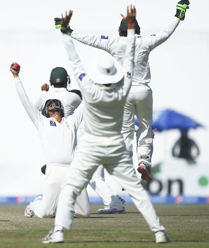 Azhar Ali of Pakistan celebrates after taking a catch to dismiss Nathan Lyon of Australia 