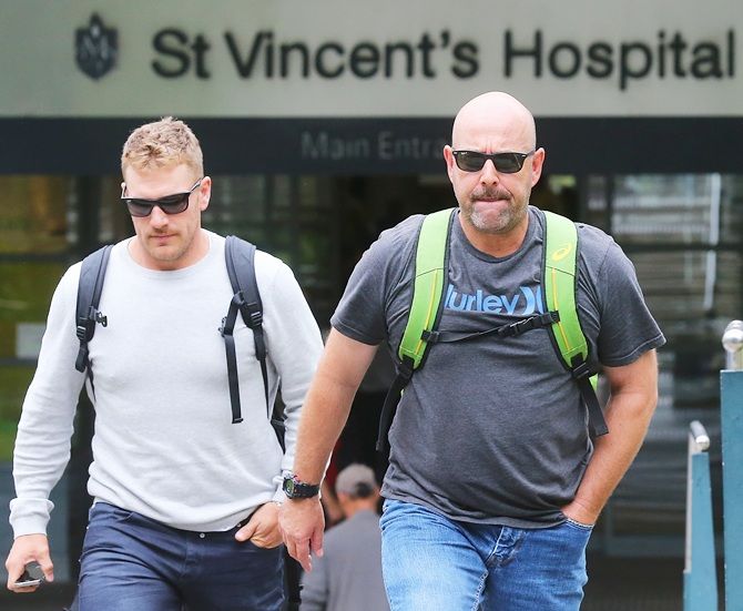 Australian cricket coach Darren Lehmann, right, and Aaron Finch leave St Vincent's Hospital