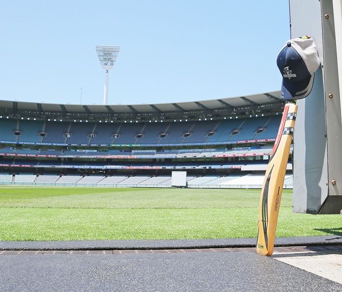 A cricket bat and cap left by a Cricket Victoria player sits in the players tunnel at the   Melbourne Cricket Ground as people remember Phillip Hughes by placing their bat and cricket   cap out the front of their homes as a sign of respect