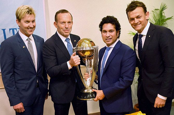 Australian Prime Minister Tony Abbott and legendary cricketer Sachin Tendulkar flanked by former Australian cricketers Adam Gilchrist and Brett Lee pose with the Cricket World Cup trophy