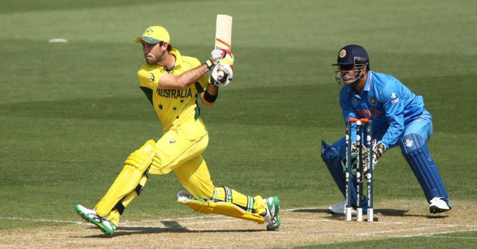 Australia's Glenn Maxwell plays a reverse-sweep as India 'keeper and captain Mahendra Singh Dhoni looks on