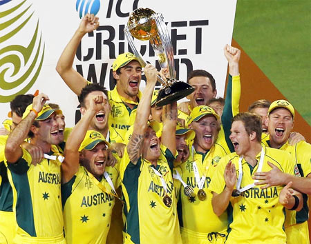 Captain Michael Clarke holds aloft the World Cup trophy as his teammates celebrate after beating New Zealand in the final at Melbourne Cricket Ground on Sunday