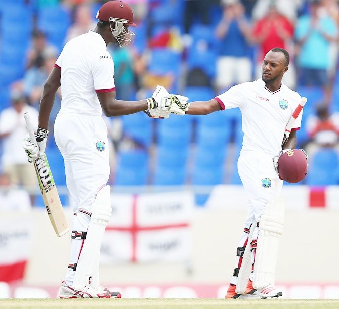 Jermaine Blackwood, right, of West Indiesis congratulated by Jason Holder 