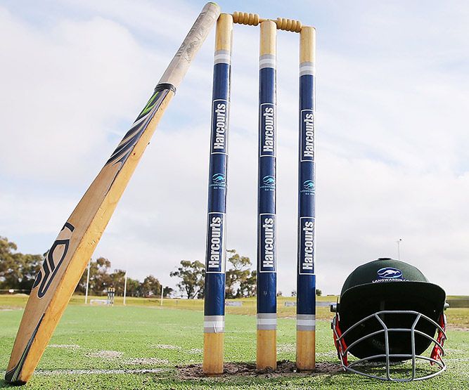 A Langwarrin club cricket bat rests on stumps, in respect for Phillip Hughes