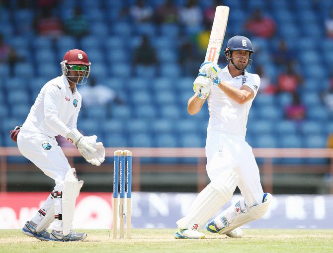 England captain Alastair Cook plays a shot on the onside as Windies captain and wicketkeeper Denesh Ramdin looks on